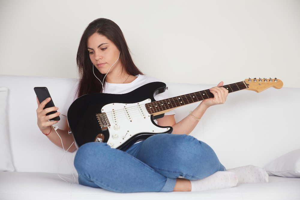 mulher aprendendo a tocar guitarra eletrica