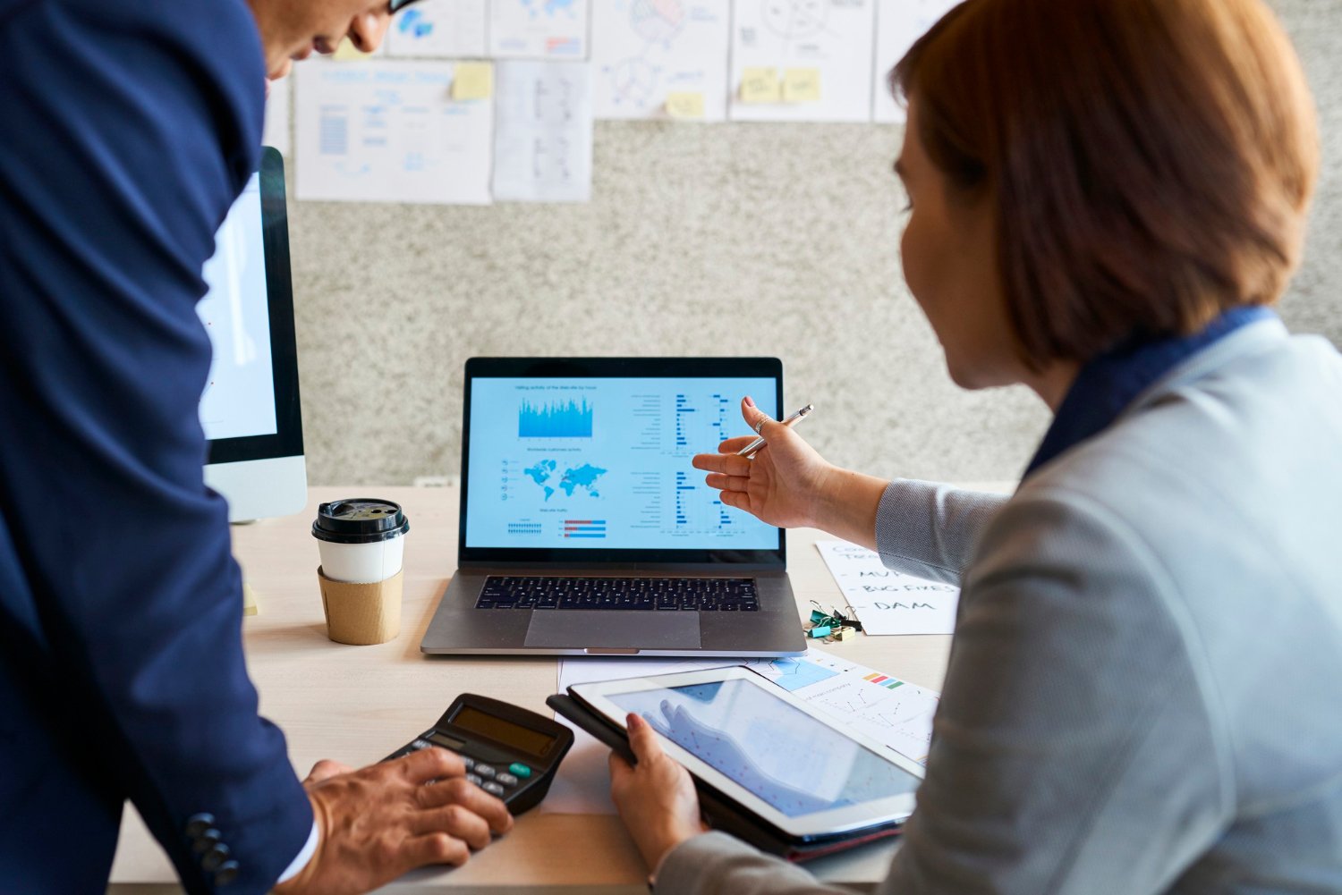 Executivos analisando riscos empresariais com inteligência artificial em dashboards digitais