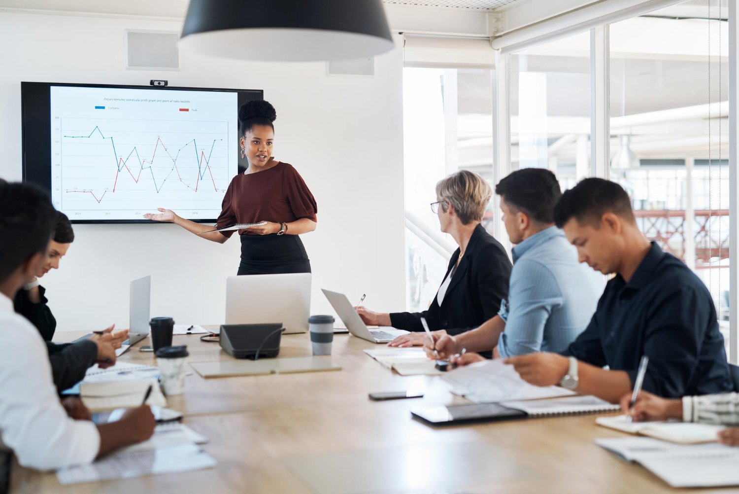Gestora apresentando gráficos de inteligência artificial em reunião corporativa