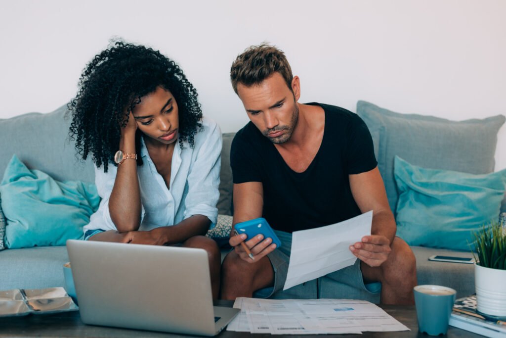 casal preocupado com dívidas e contas do casamento analisando desp