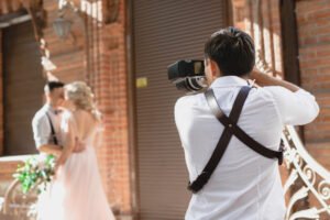 Fotógrafo registrando casal durante ensaio de casamento em momento real ao ar livre